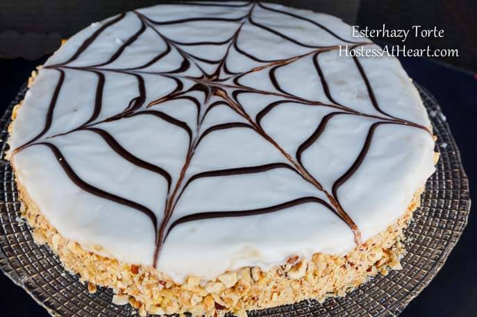 An Esterhazy torte with a spiderweb design over the top and the sides pressed with crushed nuts.