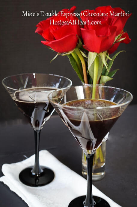 Two cocktail glasses filled with Espresso Chocolate Martinis. Red roses sit in the background.A glass of wine on a table, with Manhattan and Chocolate