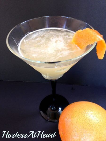A martini glass filled with a grapefruit martini.