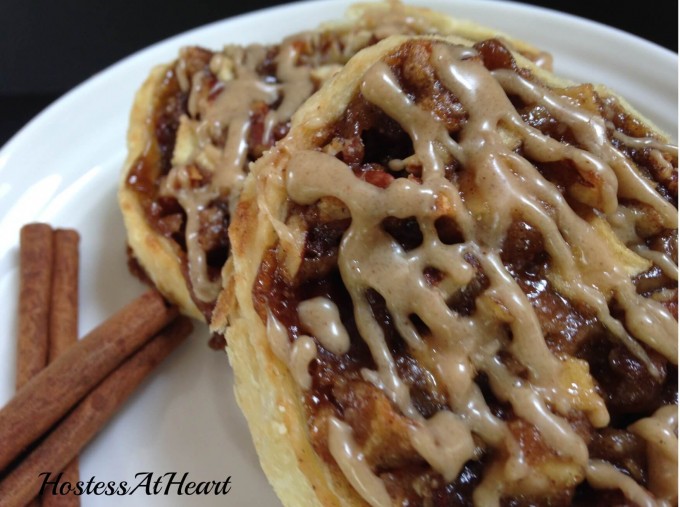 Two Apple Pecan Pastries on a white plate. A cinnamon stick sits off to the side.