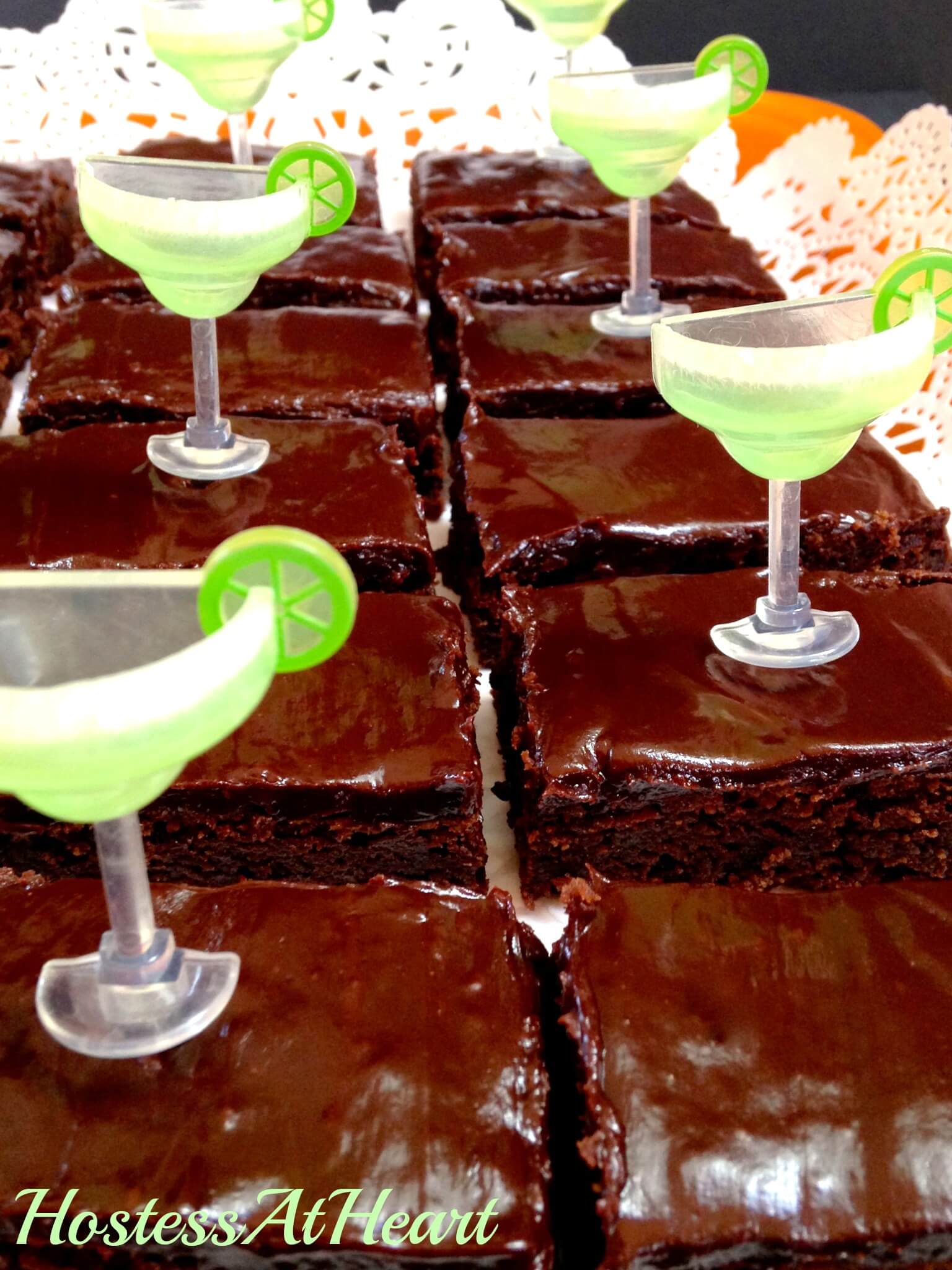 Sliced chocolate brownies frosted in chocolate frosting. Plastic margarita glasses decorate the brownies.