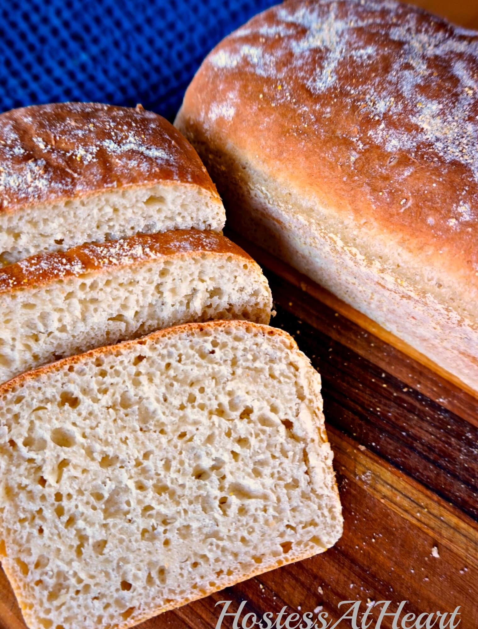 A loaf of English Muffin Bread that has slices cut from the front next to a whole loaf of bread.