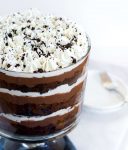 3/4 view of a Chocolate Pudding Trifle with layers of fluffy whipped topping, chocolate cake, chocolate pudding and topped with chocolate cookie crumbs