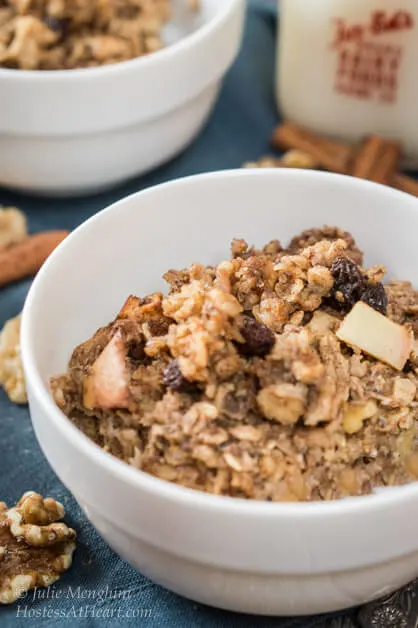 Angle view of a white bowl of Cinnamon-Apple Baked Oatmeal.