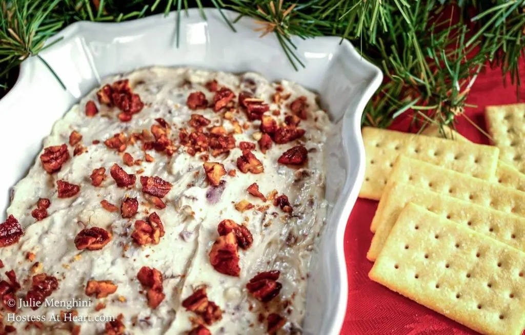 A white dish filled with Gorgonzola Cheese and Fig Dip sitting next to crackers.