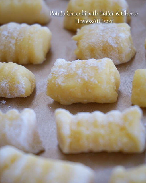 Gnocchi sitting on a tray lined with parchment paper.