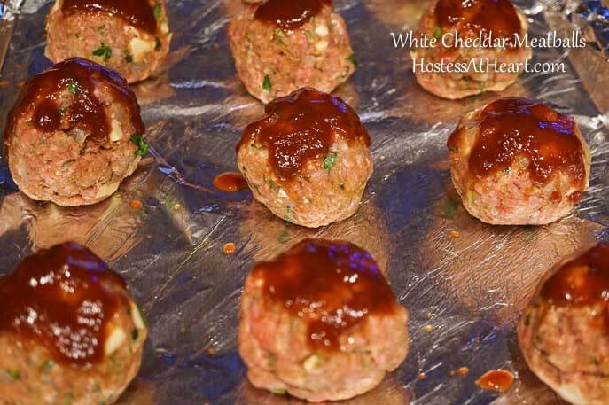 BBQ glazed meatballs on a foil-lined baking sheet.