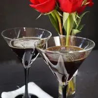 Two cocktail glasses filled with Espresso Chocolate Martinis. Red roses sit in the background.A glass of wine on a table, with Manhattan and Chocolate
