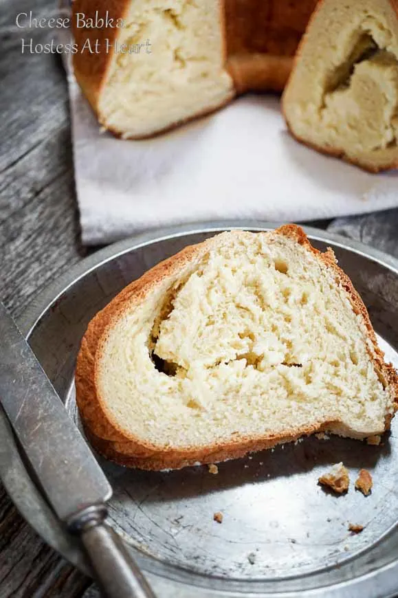 A slice of Cheese Babka Bread sitting on an antique pie tin with the sliced loaf in the background.