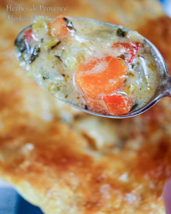 A close up of the filling on a spoon hovering over the pot pie.