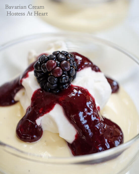 A glass dish filled with Bavarian Cream topped with a Blackberry Coulis and garnished with a fresh blackberry.