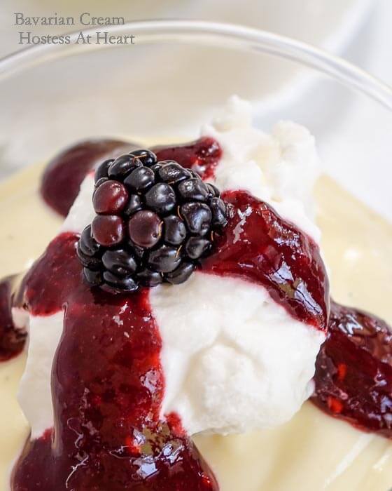 A glass dish filled with Bavarian Cream topped with a Blackberry Coulis and garnished with a fresh blackberry.