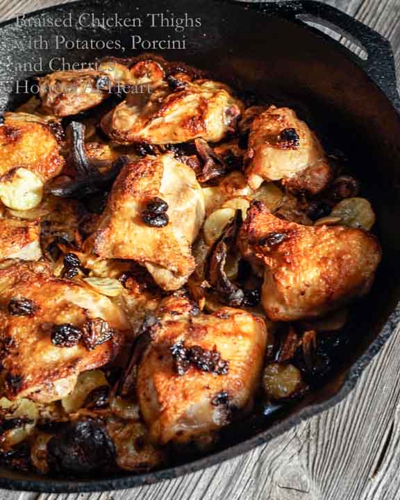 Cast Iron pan filled with cooked chicken thighs with potatoes, Porcini & dried cherries.  