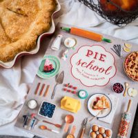 A book on pie sits next to a baked pie.