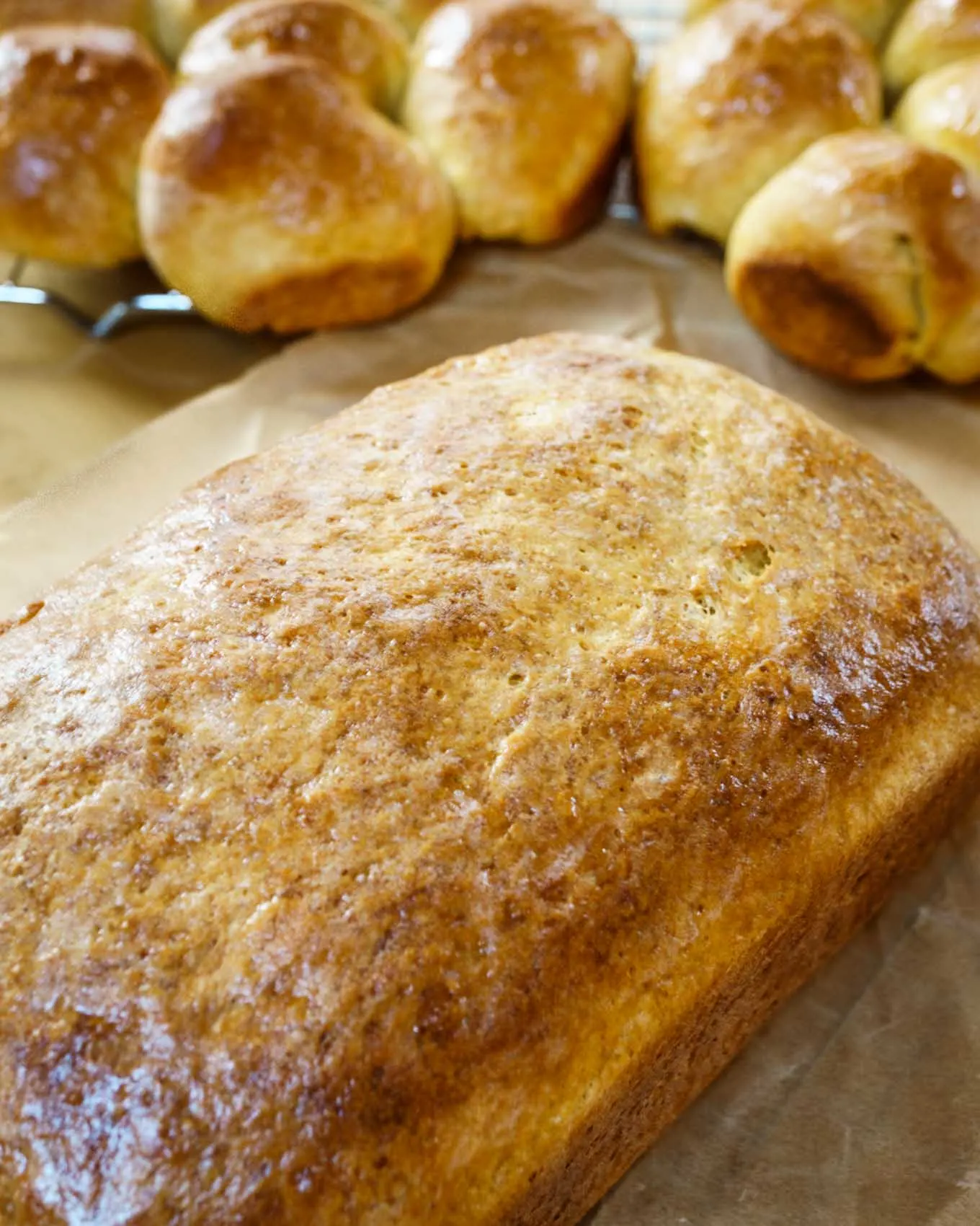 A loaf of Pumpkin Yeast Bread with individual rolls in the background.