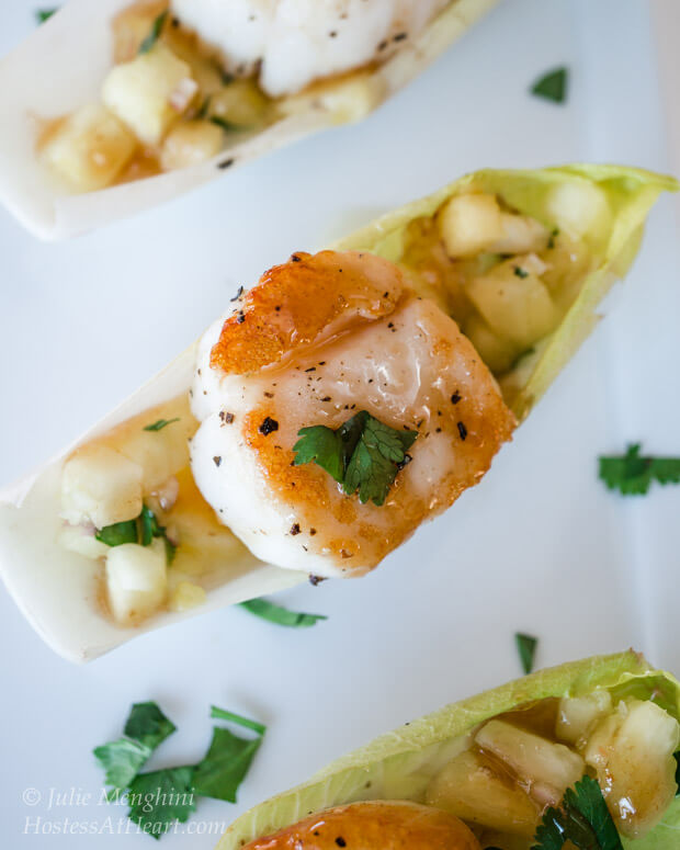 An Endive lettuce leaf filled with a cooked scallop and pineapple salsa.