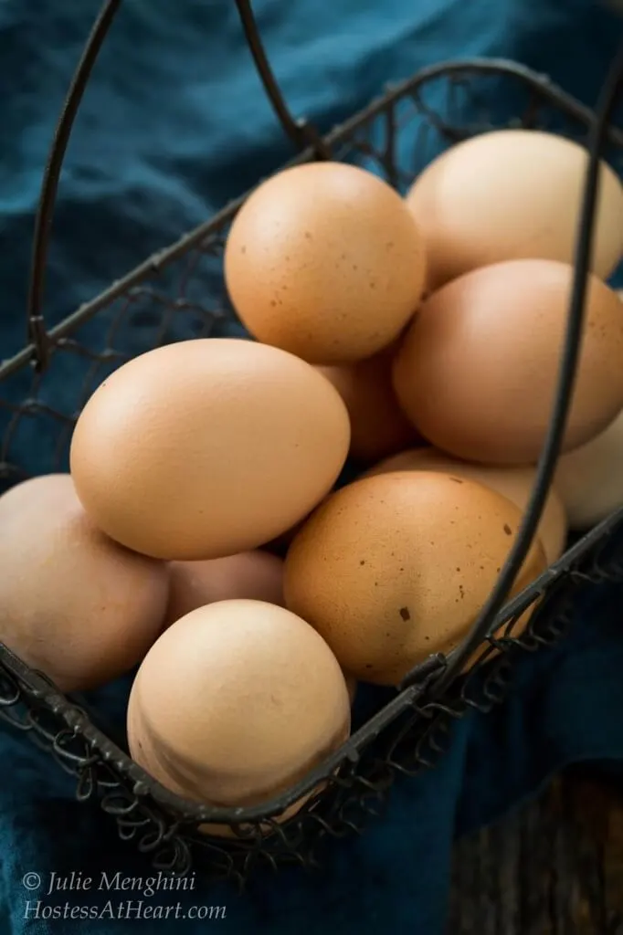 Eggs sitting in a wire basket.