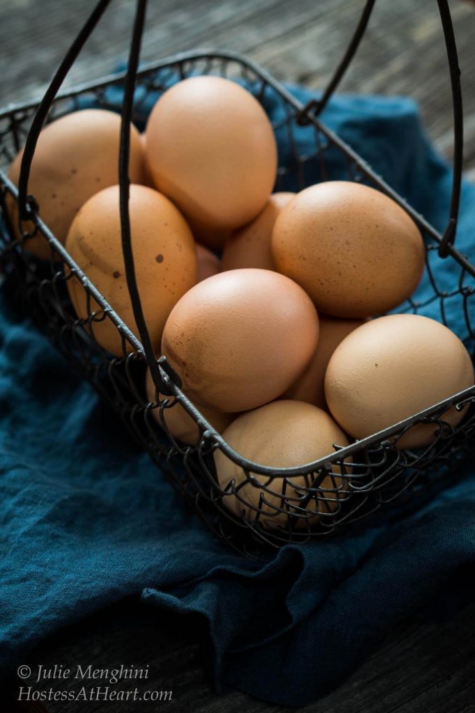 Eggs sitting in a wire basket.