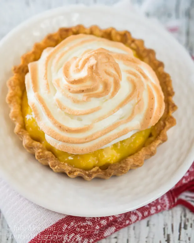 A pineapple meringue tart sitting on a white plate.