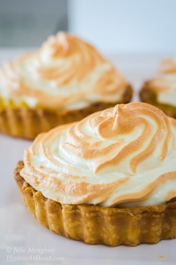 Two Pineapple Meringue Tart sitting on white plates.