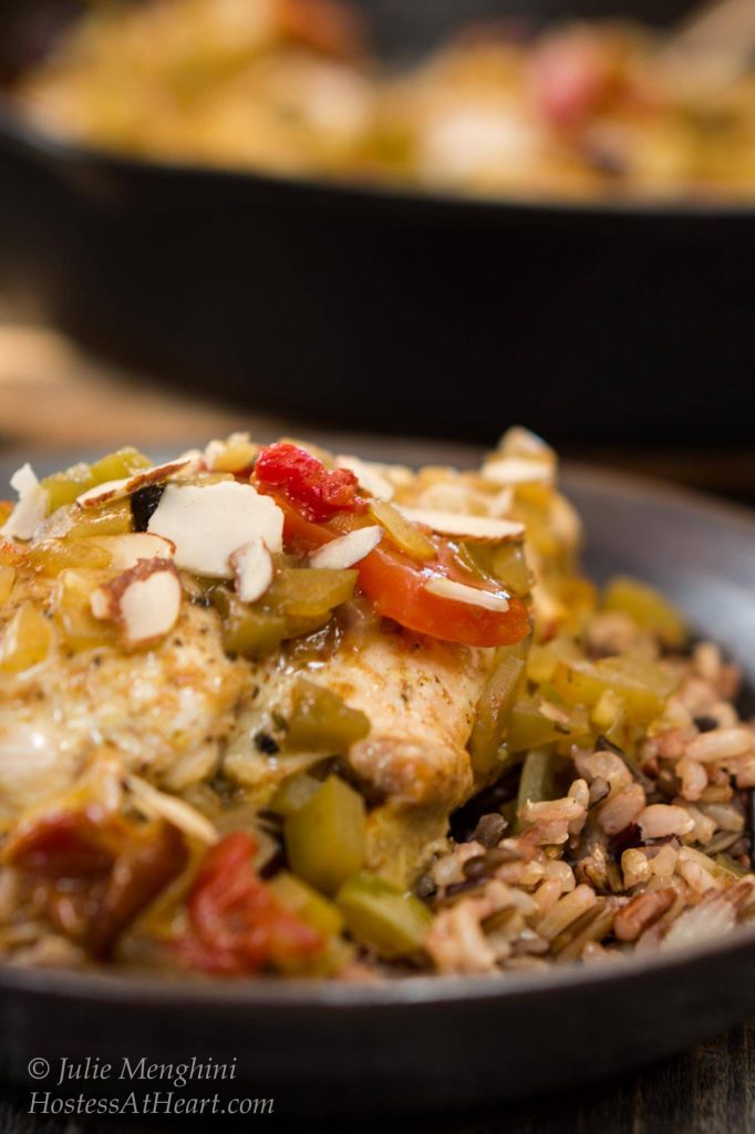 Indian flavored Chicken breast over a bed of rice topped with stewed tomatoes, green peppers, and sliced almonds.