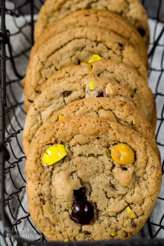 A row of M&M cookies sitting in a wire basket.