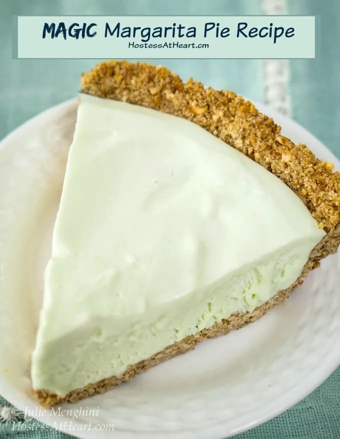 A green-colored slice of a frozen Margarita pie with a graham cracker crust sitting on a white plate over a turquoise napkin. The title \"Magic Margarita Pie Recipe\" appears at the top.