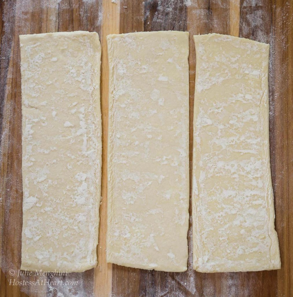 A piece of puff pastry sliced in three pieces.