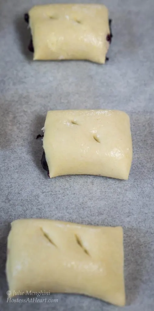 A filled and rolled piece of puff pastry sliced into individual rolls prior to baking.