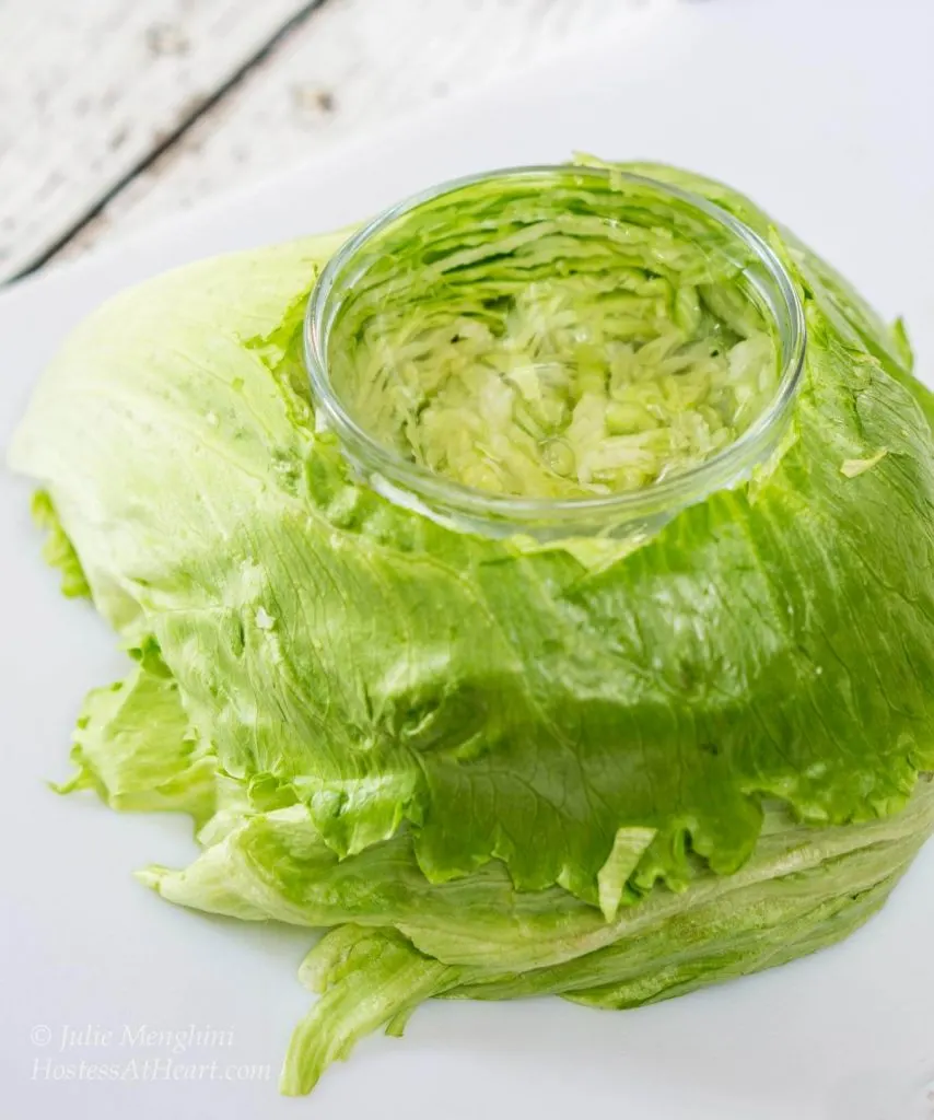 Photo showing how to hollow out the top of a head of lettuce and adding a bowl for avocado sauce.