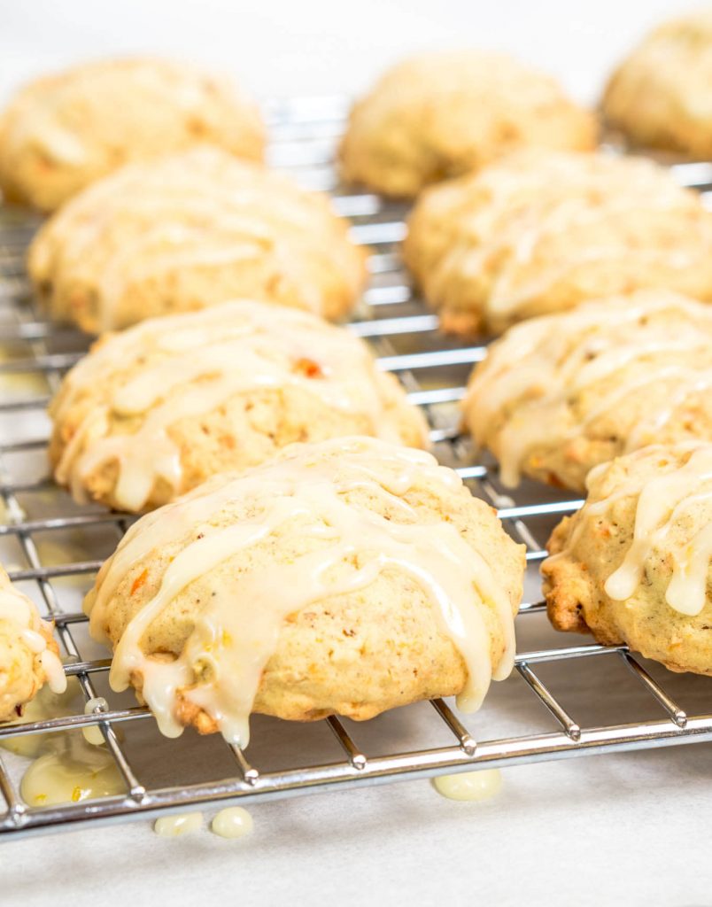 A cooling rack holding Citrus Carrot Cookies over a piece of parchment paper.