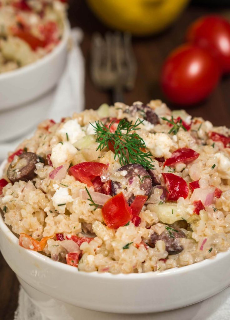 Tabouli Salad in a white bowl with tomatoes and dill topping