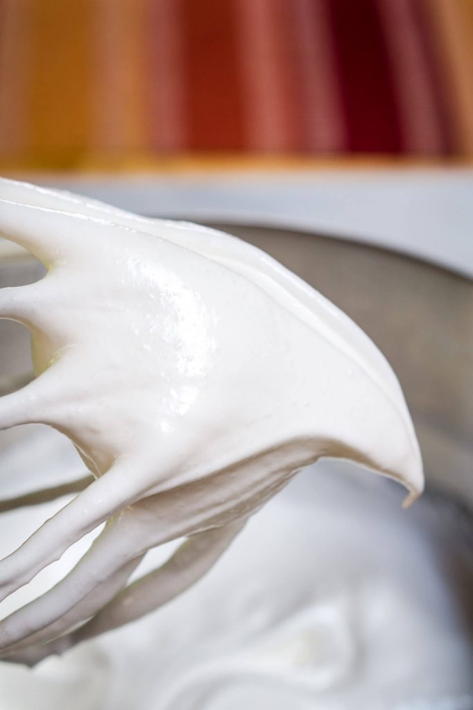A whisk attachment filled with meringue showing a still peak | HostessAtHeart.com