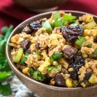 A bowl filled with Cherry Chipotle Salad that's loaded with dried cherries, corn, and cilantro.