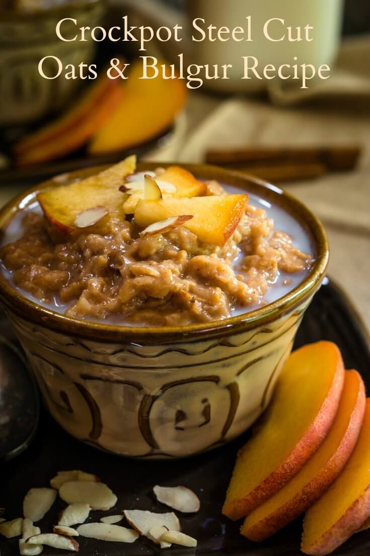 A yellow dish filled with Steel-cut Oats and Bulgar that\'s topped with warm milk, cinnamon, fresh peaches, and nuts. Fresh sliced peaches sit to the side.  