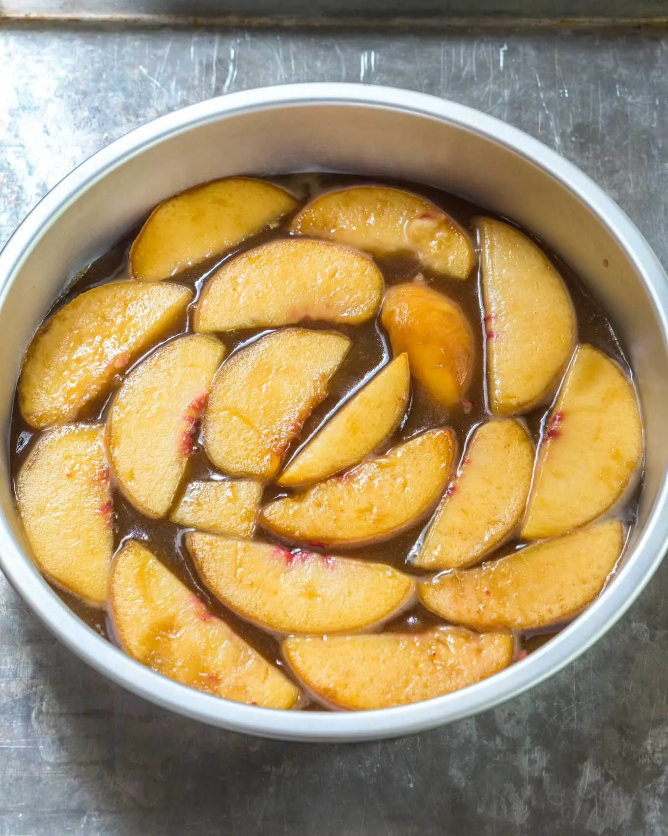 Fruit and sauce in the bottom of a cake pan.