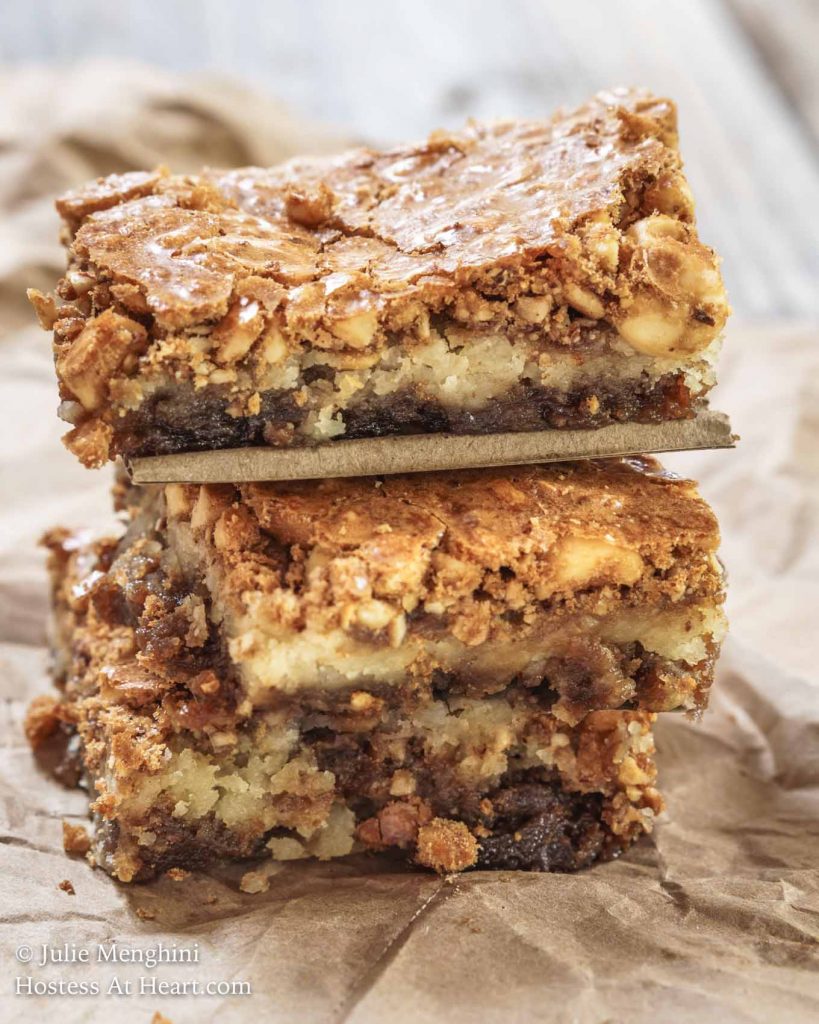 A stack of Hazelnut Cookie Bars sitting on a piece of parchment paper.