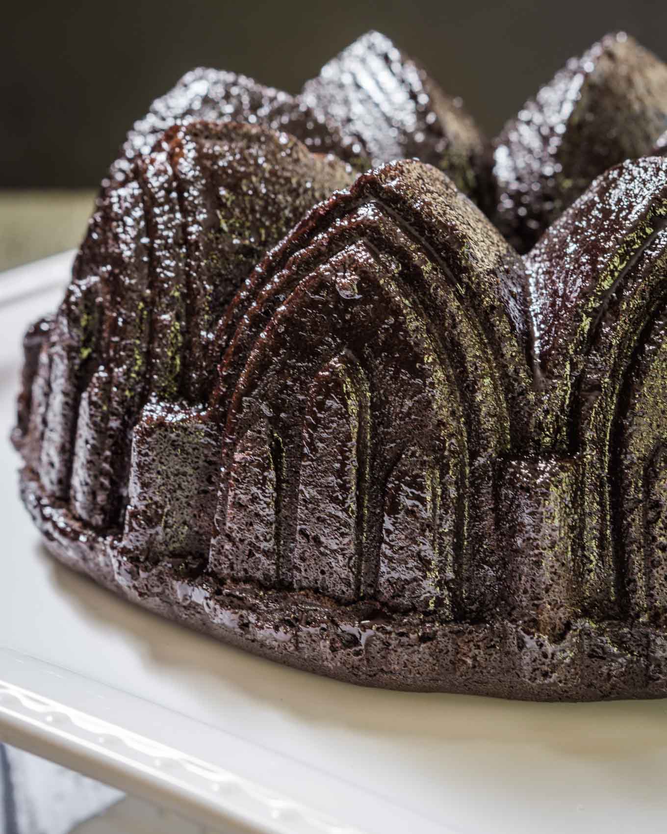 A top-angled view of a raspberry glazed chocolate raspberry bundt pan sitting on a white plate.