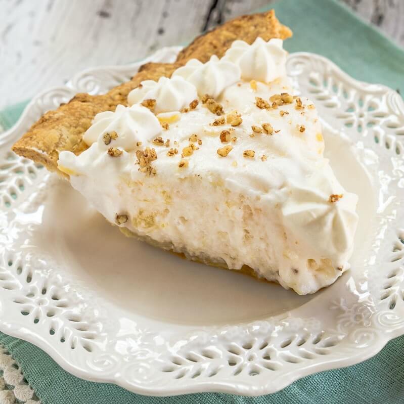 A slice of an Angel Food Pie sitting on a decorative white plate over a turquoise napkin.