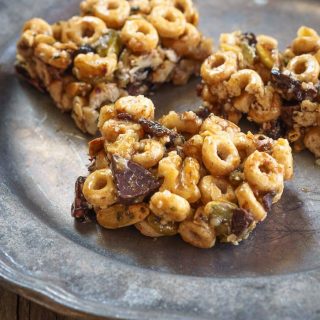 A healthy snack bar made from cereal, honey, and dark chocolate on a metal plate.