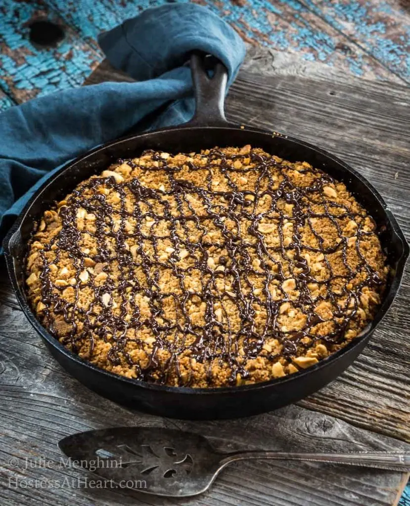 Uncut Peanut Butter Coffee cake in a cast-iron skillet with the handle wrapped with a blue napkin
