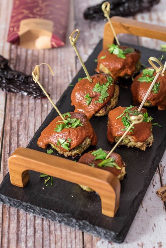 A tray of 6 meatballs with bamboo serving skewers stuck into the top.