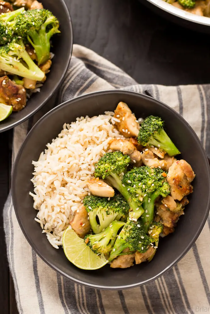 A bowl diced chicken, broccoli, and rice on a striped towel.