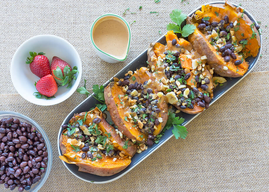 Sweet Potatoes baked and stuffed in an oval dish.