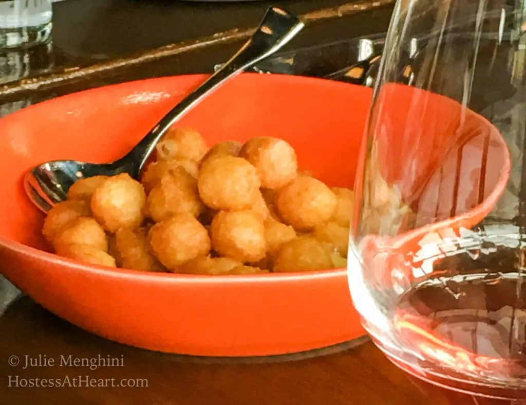 An orange bowl filled with potato puffs.