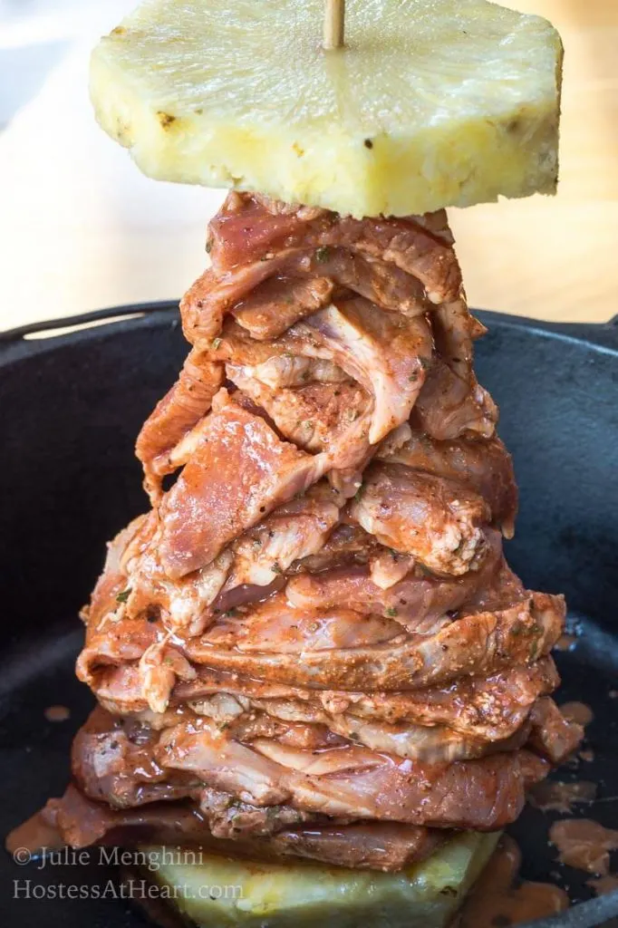 Stacked pork seasoned with Al Pastor sauce & spices then topped with a slice of pineapple ready for grilling.