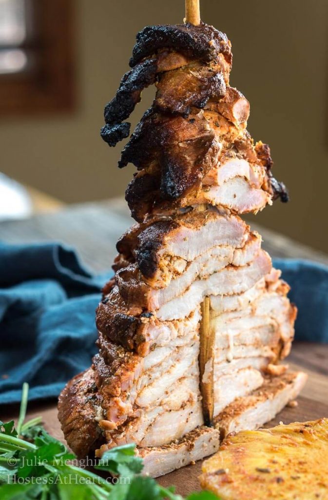 Grilled and stacked pork seasoned with Al Pastor sauce & spices that\'s been cut in half showing the layers.