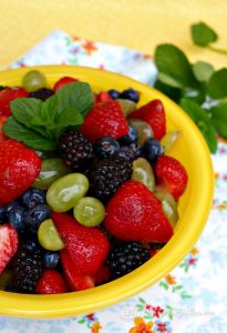 A bowl of fresh fruit in a yellow bowl.