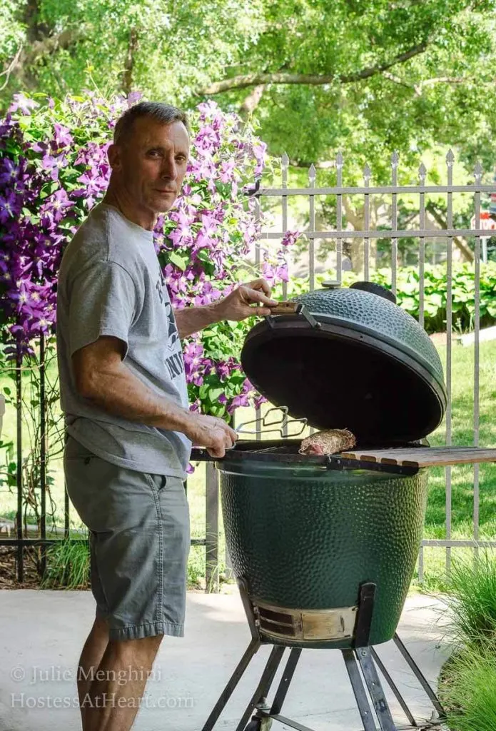 A man standing in front of Big Green Egg grill.