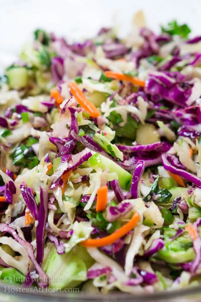 A close up of a bowl of Thai Basil Cabbage slaw with purple cabbage and carrot sticks.